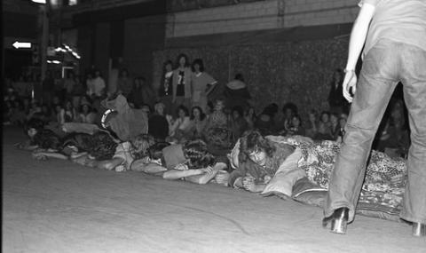 Students Laying under Blankets on Street