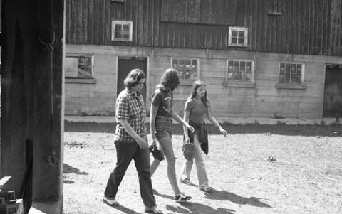 Three Students Walking Past Stables