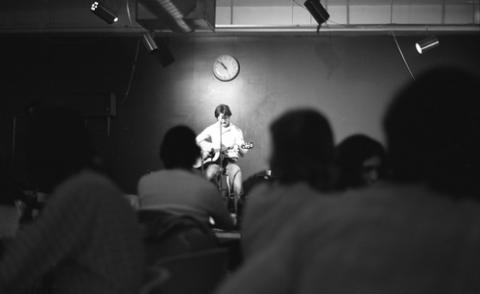 Person Onstage Playing Guitar in College Pub