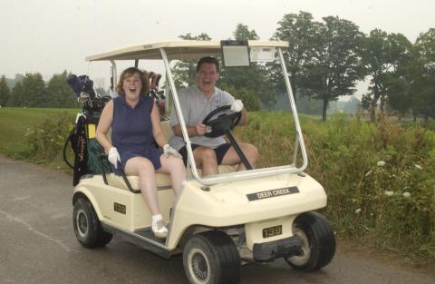 Two Players in Golf Cart Laughing and Gesturing at Camera, Management Alumni Association Golf Tournament, 2002, Deer Creek Golf Club