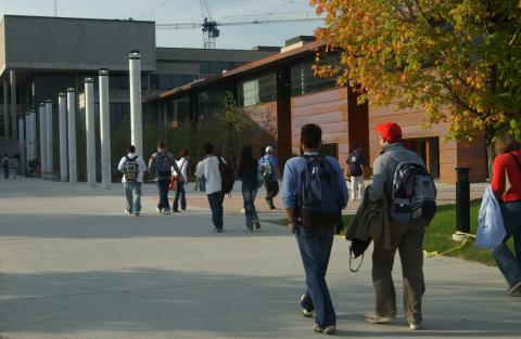 Students Walk along ARC Walkway, Construction Crane Visible Behind Bladen Wing