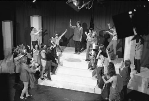 Costumed Students With Raised Arms Onstage