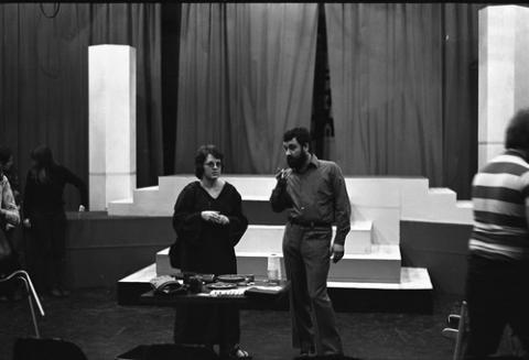 Two People Standing By Table Smoking